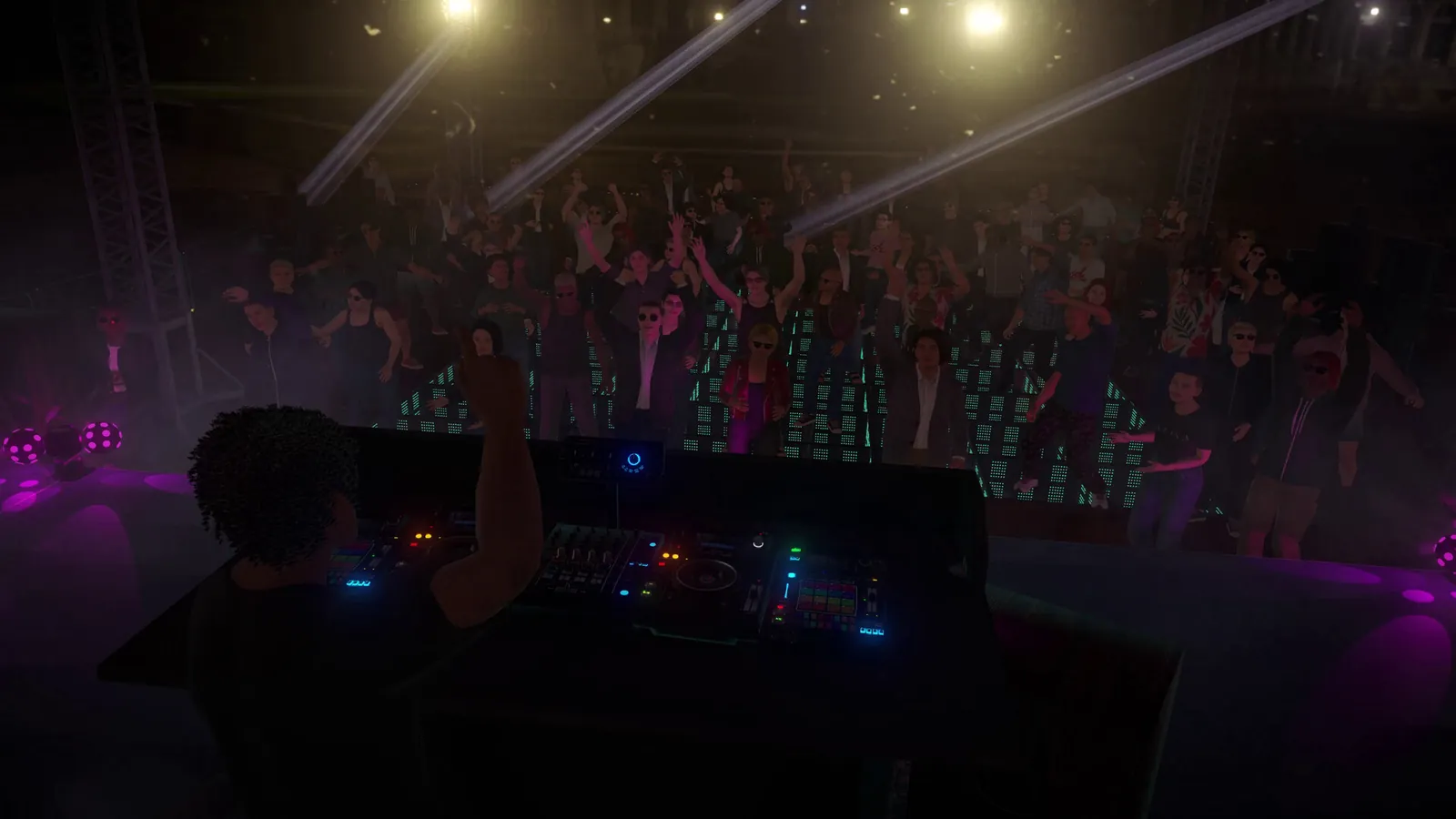 A festival crowd with hands up in front of the DJ booth